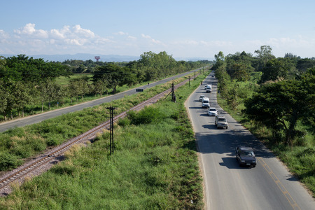 The people are traveling on the highway ring road of Chiang Mai city along with railway. December, 02-2015 Chiang Mai, Thailand.の写真素材