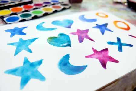 Watercolor symbol painting on white paper with color swatch tablets, in studying class. Image for education.の写真素材