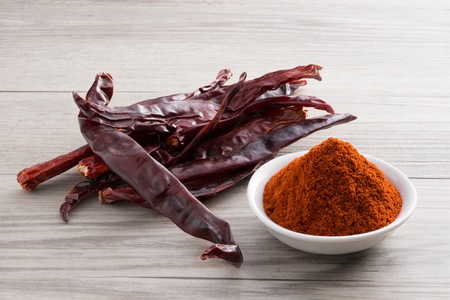 Dry chilii spices on wooden texture background