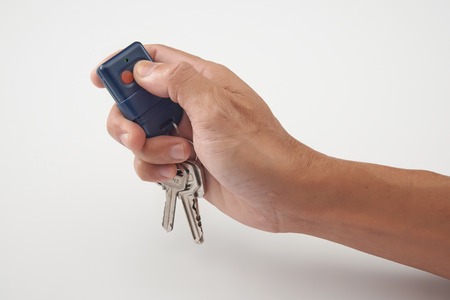 Hand press the remote control with keys in clean backgroundの写真素材