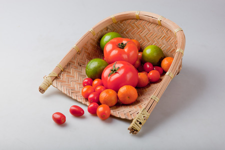 Assortment of exotic fruits in basket, isolated on whiteの写真素材