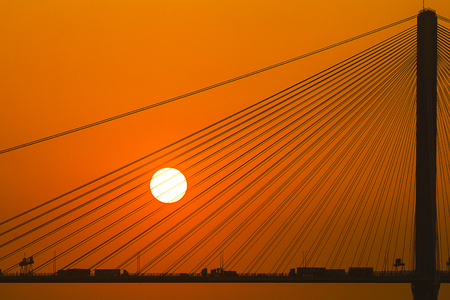 Silhouette of a bridge under setting sunの写真素材