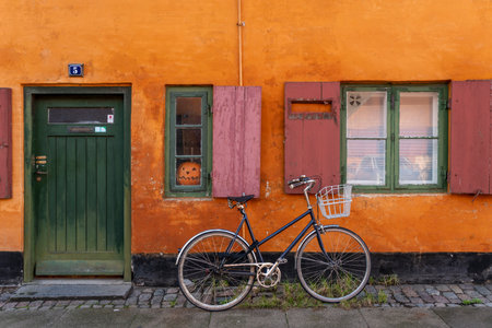A picturesque European street comes to life in this image, where a vintage bicycle with a front...