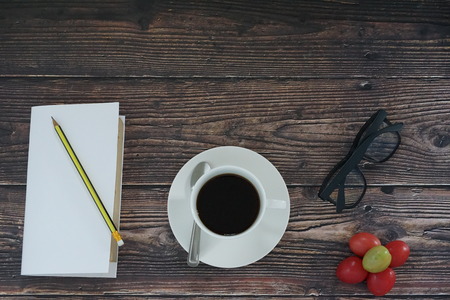Coffee, books, glasses on the deskの写真素材