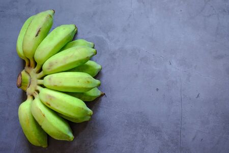 Green banana placed on the cement floorの写真素材