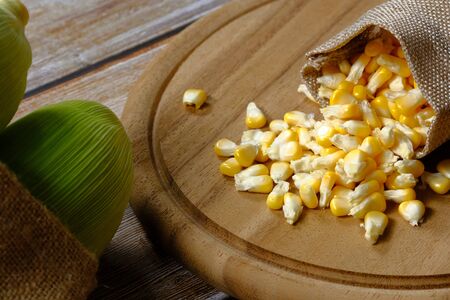 Yellow corn kernels on the wood floorの写真素材
