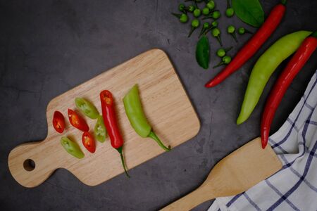 Red-green peppers on a black wooden floor in the kitchen