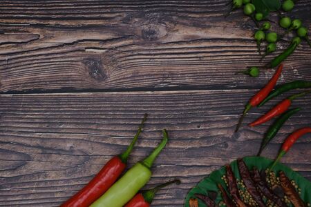 Red-green chillies on the wood floor in the kitchenの写真素材