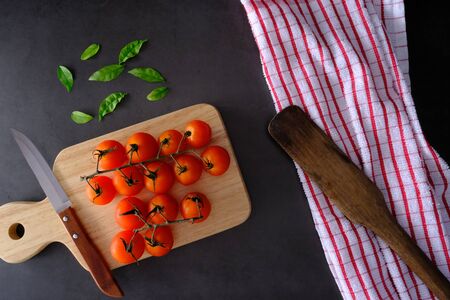 Tomatoes on the black wooden floor in the kitchenの写真素材