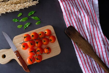 Tomatoes on the black wooden floor in the kitchenの写真素材