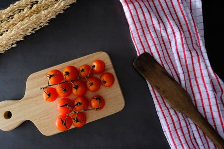 Tomatoes on the black wooden floor in the kitchenの写真素材