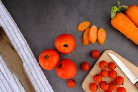 Tomatoes on the black wooden floor in the kitchenの写真素材