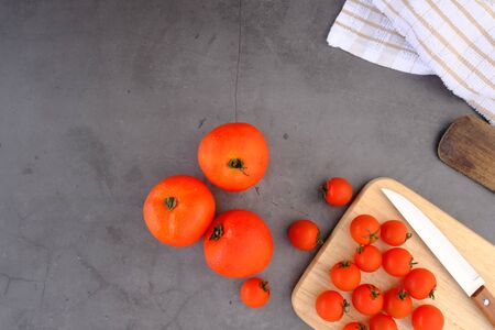 Tomatoes on the black wooden floor in the kitchenの写真素材