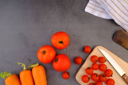 Tomatoes on the black wooden floor in the kitchenの写真素材
