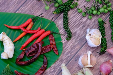 Chili, onion, garlic on the wooden floor in the kitchenの写真素材