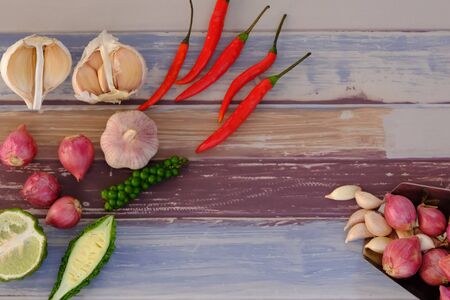 Peppers, onions, garlic and spices on the wood floor in the kitchenの写真素材