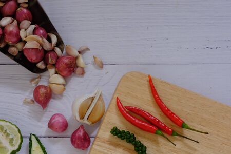 Peppers, onions, garlic and spices on the wood floor in the kitchenの写真素材