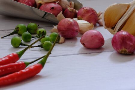 Peppers, onions, garlic and spices on the wood floor in the kitchenの写真素材