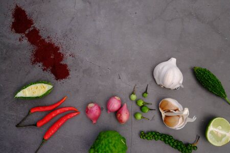Peppers, onions, garlic and spices on the black wooden floor in the kitchenの写真素材