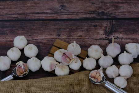 White garlic on the wooden floor in the kitchen for cookingの写真素材