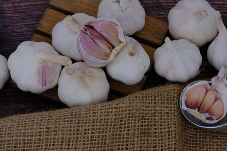 White garlic on the wooden floor in the kitchen for cookingの写真素材