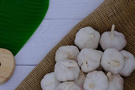 White garlic on the wooden floor in the kitchenの写真素材