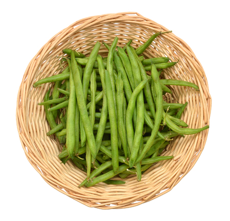 Green beans with leaves in basket on white backgroundの写真素材