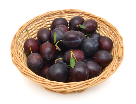 Sweet and ripe plums in basket on whiteの写真素材
