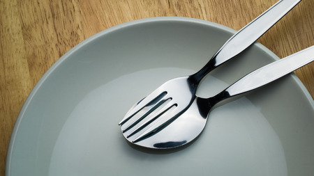 Close up spoon and fork , kitchenware, in a green ceramic plate.