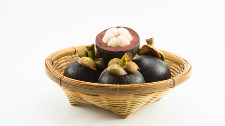 mangosteens in bamboo basket isolated on white backgroundの写真素材