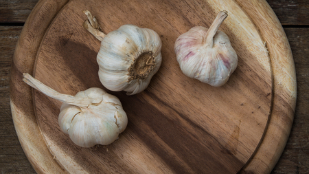 Closeup 3 garlic lobes on the wooden block from the top viewpoint.の写真素材