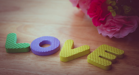 LOVE word made from foam alphabets place on wooden table- pink color toneの写真素材