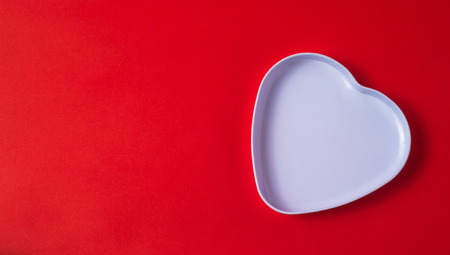 the heart-shaped box on red background- space for textの写真素材