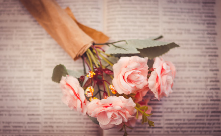 Artificial roses place on unfocused book- select focus and pink color effectの写真素材