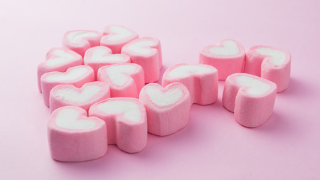 Pink heart-shaped marshmallow in with pink backgroundの写真素材