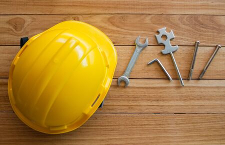 safety helmet and tools on wooden board from top viewの写真素材