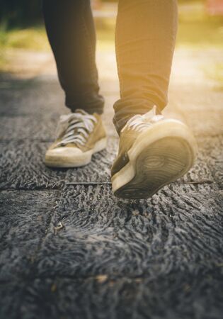 close up man's shoes while walking on street