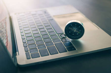 metallic compass on laptop, internet technology concept, in vintage color tone select focus and blurryの写真素材