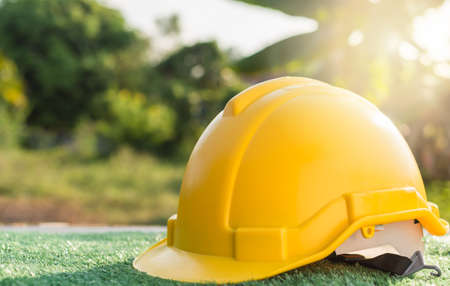 close up yellow safety helmet on the grass floorの写真素材