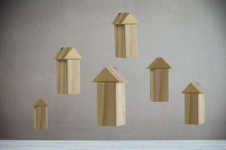 Floating wooden block stack as arrow against grey background with vignette, businesses growing concept and symbolの写真素材