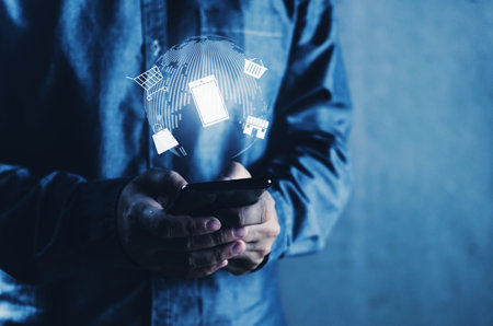 Image of human hand holding a mobile phone for business activities in the image contains icons...