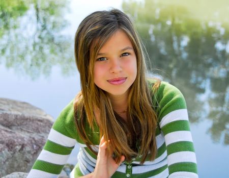 young pretty girl outdoors by a pondの写真素材