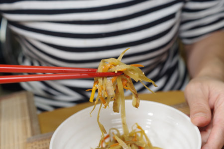 A woman is eating kinpira burdockの写真素材