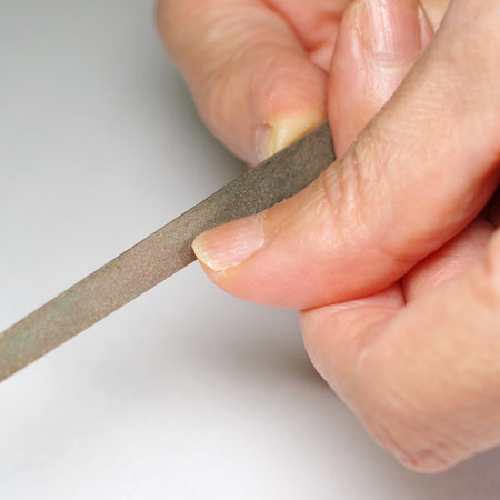 scraping nail with a fileの写真素材