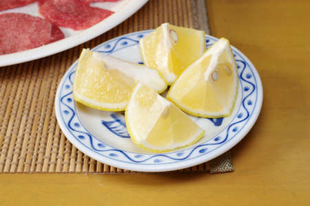 Cut lemon on a small plateの写真素材