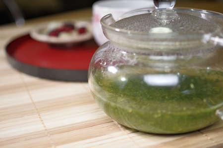 Green tea is brewed in a transparent teapot