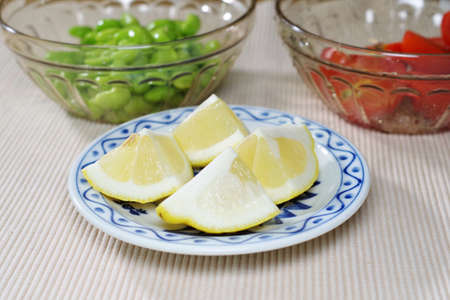 Peeled green soybeans, small tomatoes and cut lemonsの写真素材