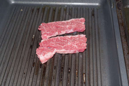 Cooking sliced beef on the iron plateの写真素材