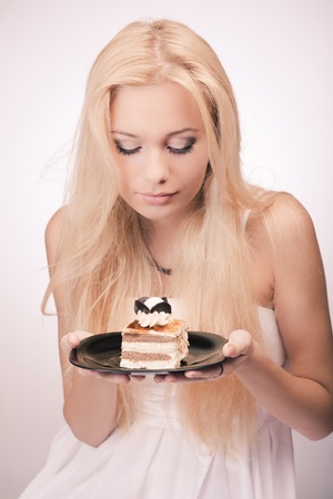Young pretty girl with a cake on the plateの写真素材