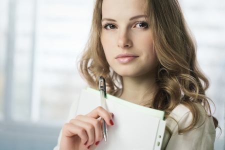 Portrait of young attractive student girl with papersの写真素材